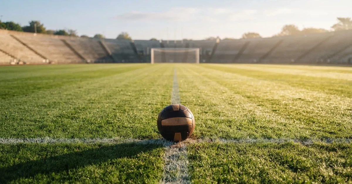 A ball on the centre spot of a grass pitch in morning light