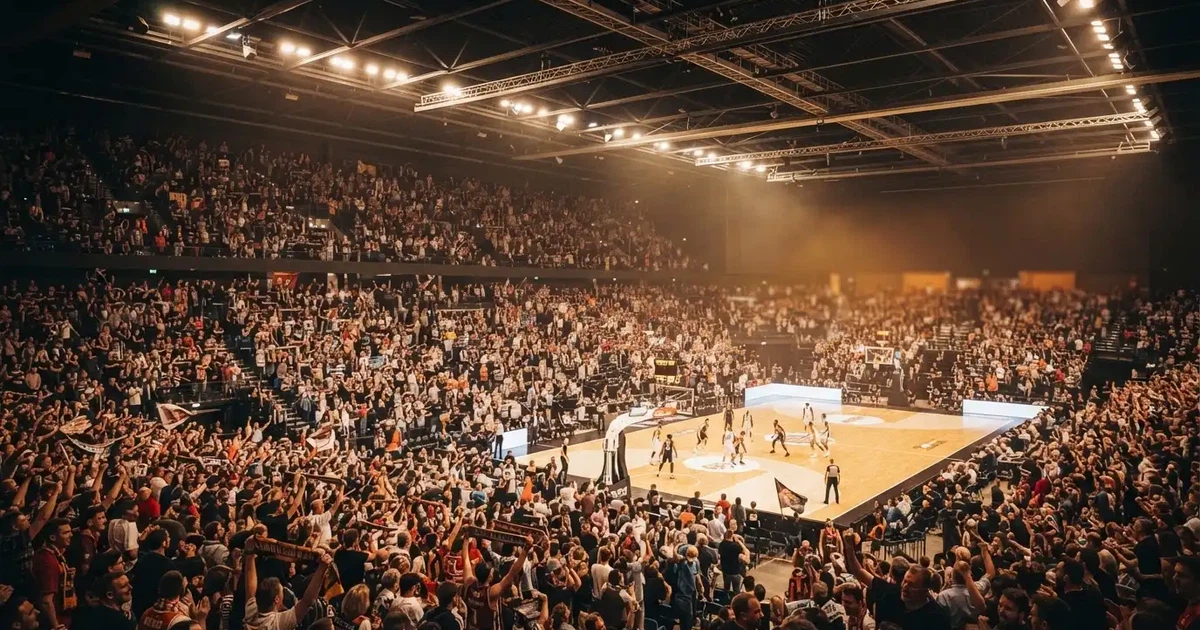 A packed sports hall under floodlights photographed from a long way off