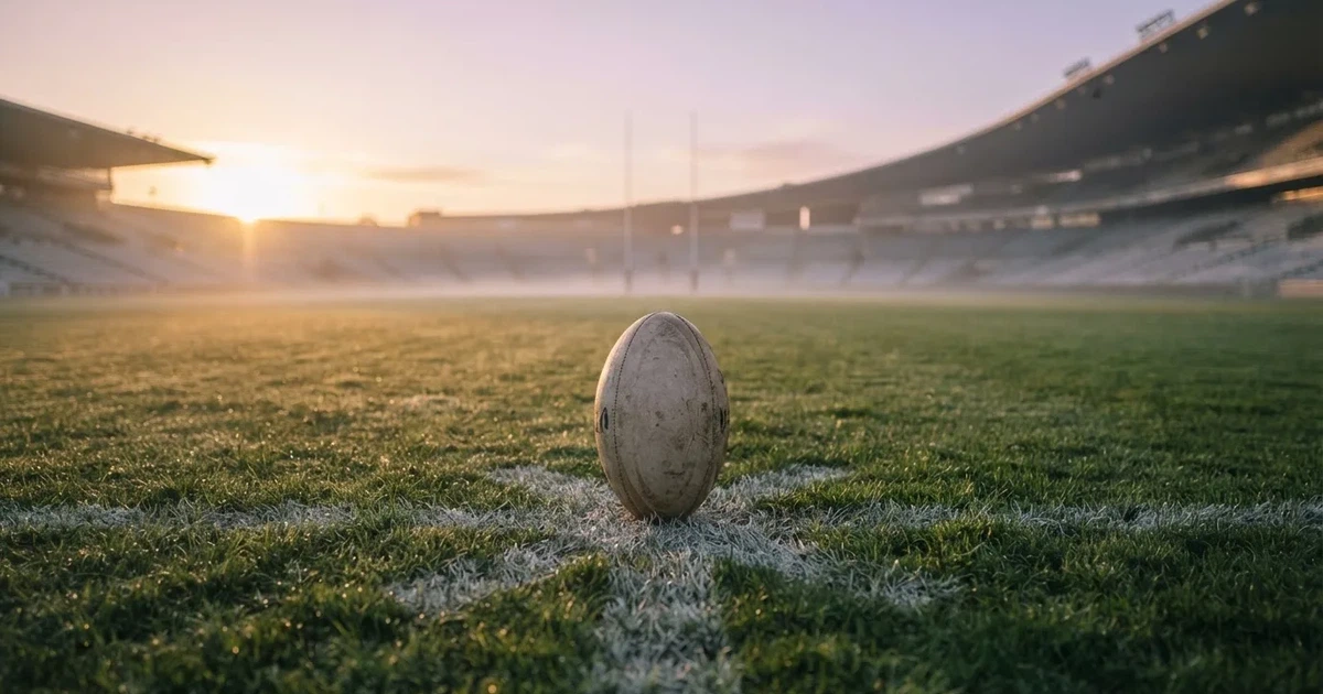 A ball on the centre spot of a grass pitch in morning light
